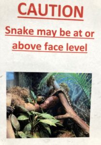 Sign warning that snakes may be at, or above, face level.